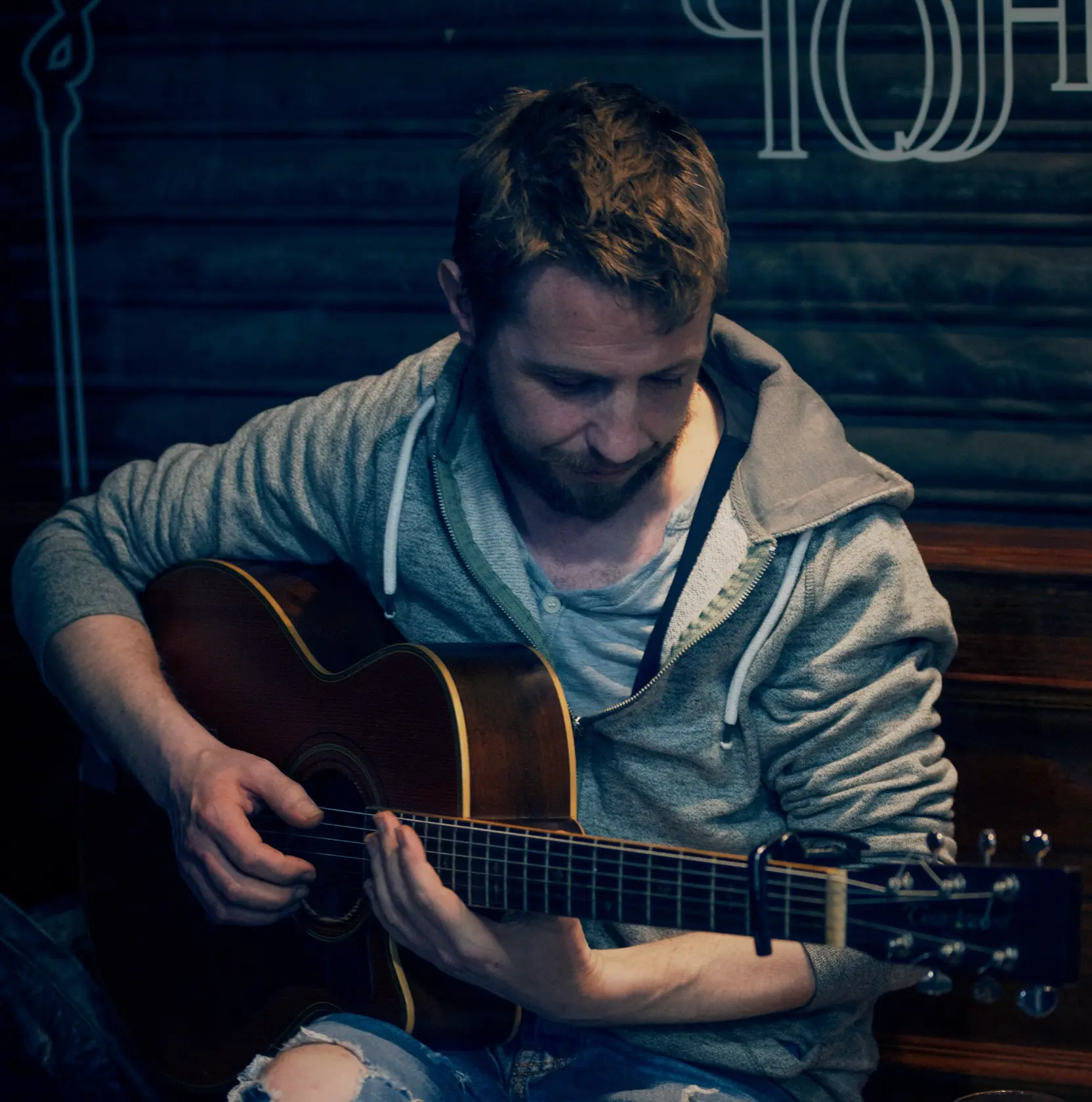 Ciaran McElhinney playing an acoustic guitar