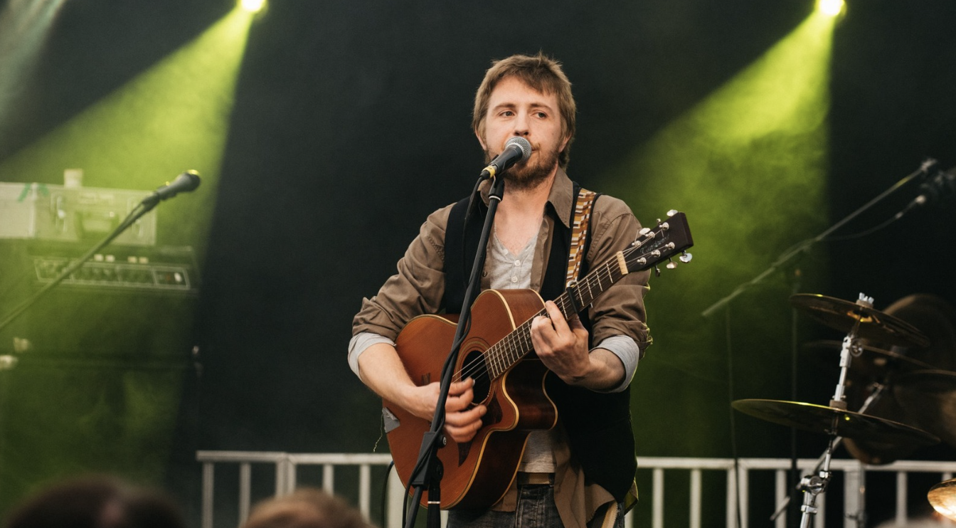 Ciaran performing on stage under green lights